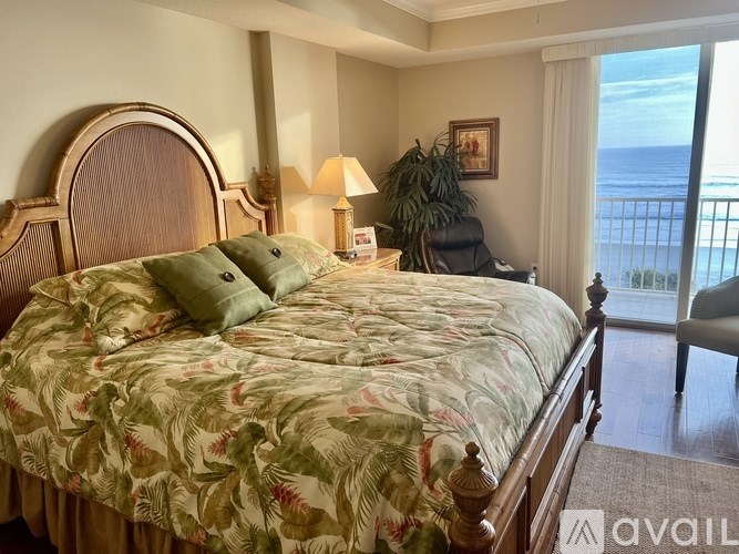 A bedroom with a large bed and a view of the ocean.