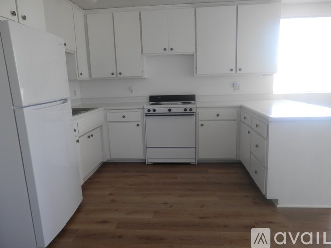 A kitchen with white appliances and cabinets.