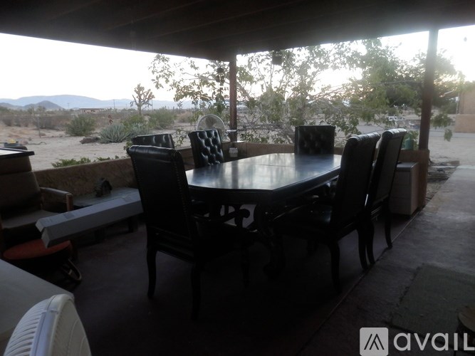 A patio with a table and chairs under a roof.
