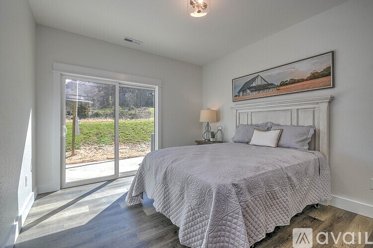 A bedroom with a large bed and a painting on the wall.