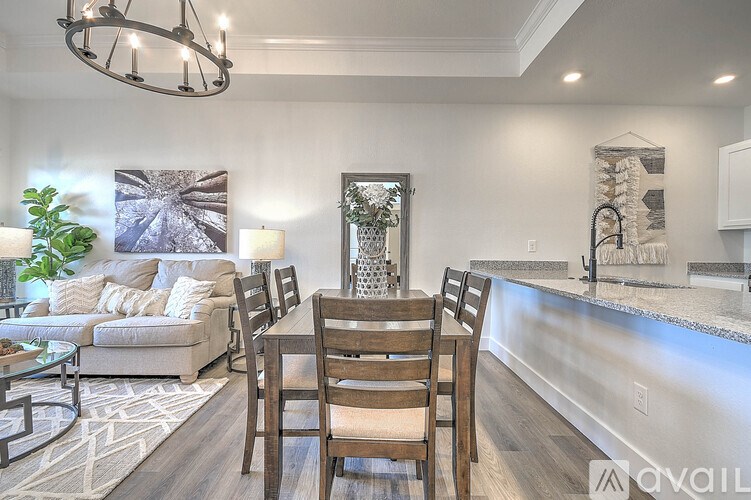 A modern dining room with a glass table and chairs.