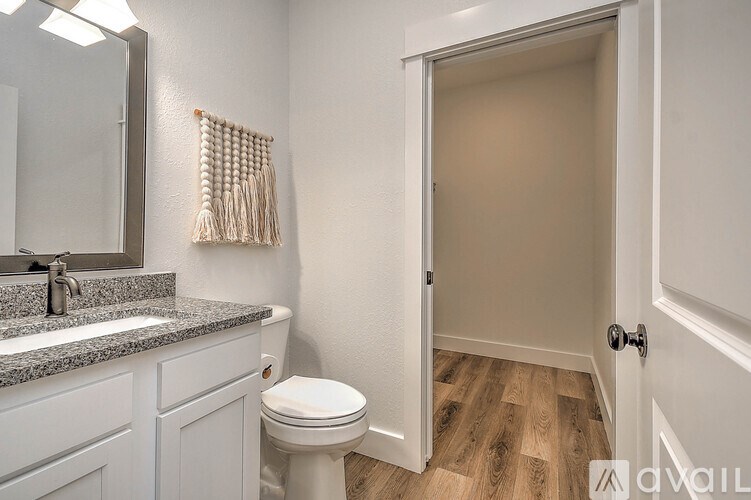 A bathroom with a toilet, sink, and a door.
