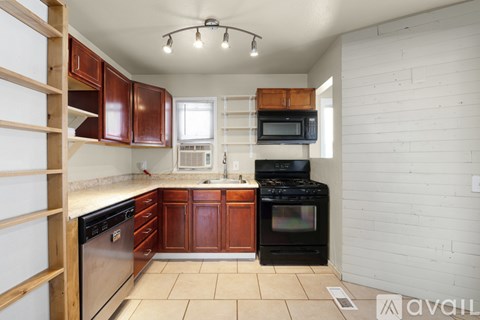 A kitchen with white walls and wooden cabinets.