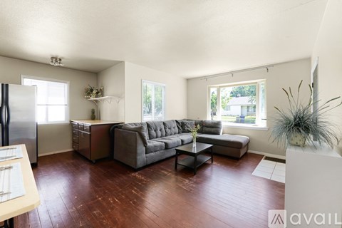 A living room with a grey couch and a wooden floor.