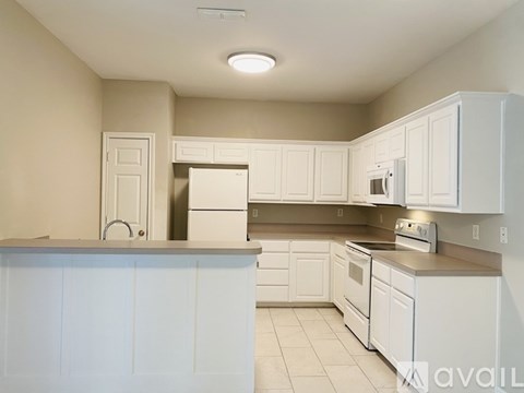 A kitchen with white cabinets and appliances.