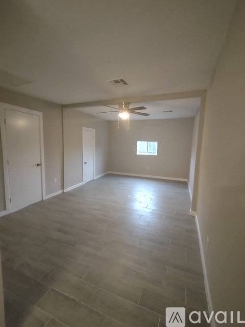 A spacious room with a ceiling fan and a window.