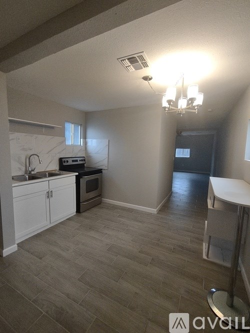 A kitchen with a microwave, oven, sink, and cabinets.
