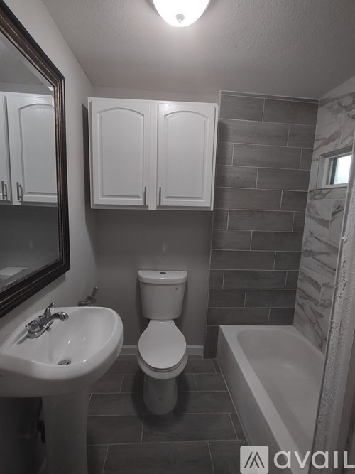 A bathroom with a toilet, sink, and bathtub.