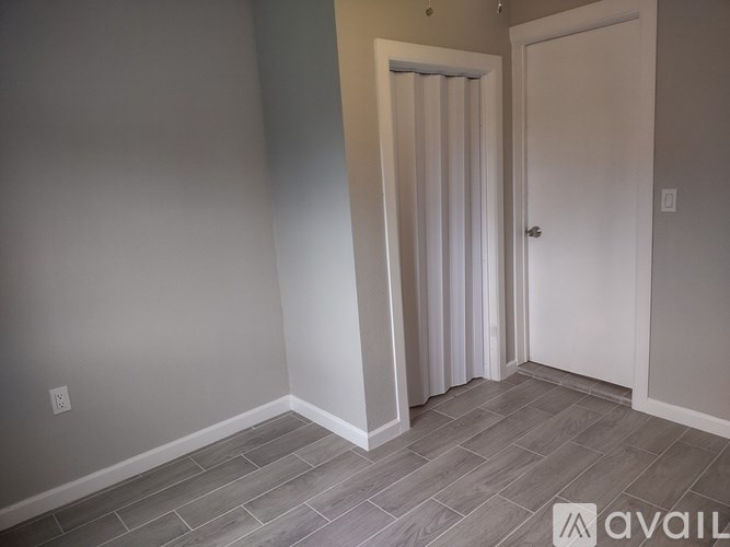 A room with a door and a window with curtains.