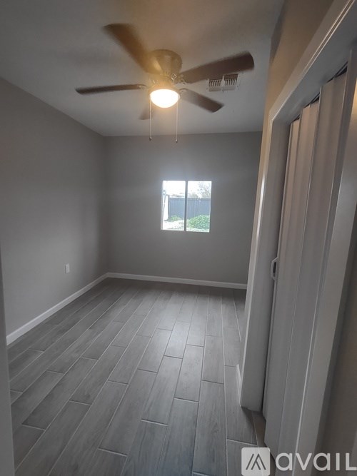 A room with a ceiling fan and a window.