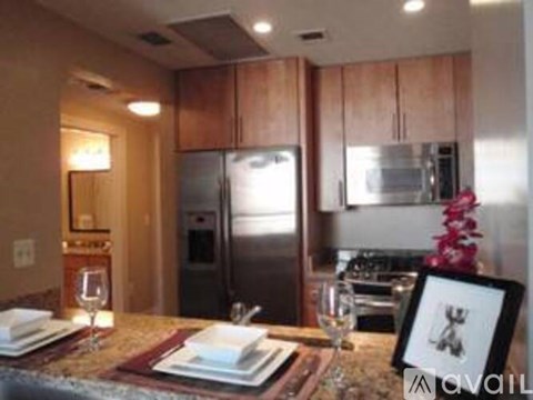 A modern kitchen with a dining table set for two.