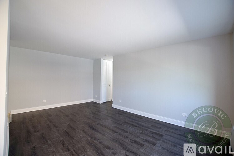 A room with wooden flooring and white walls is available for rent.