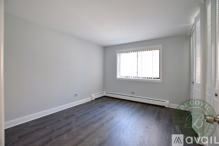 A room with a window and wooden flooring.