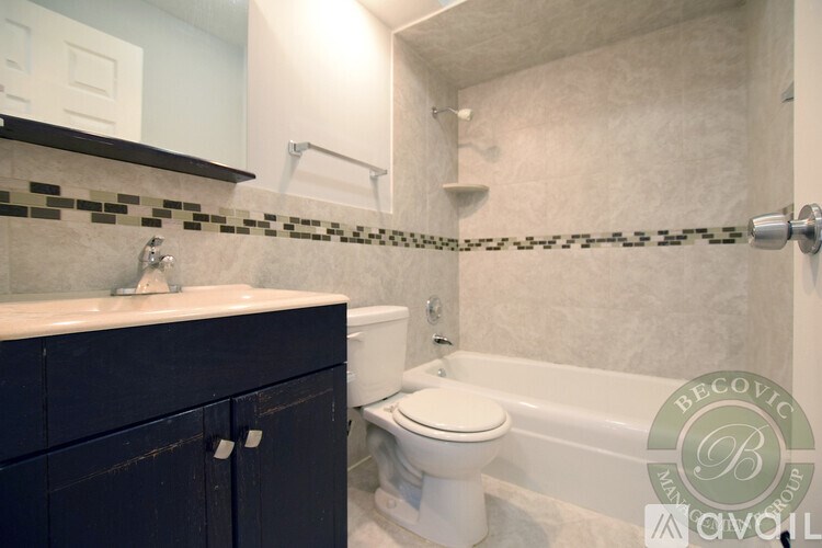 A bathroom with a white toilet and a white bathtub.