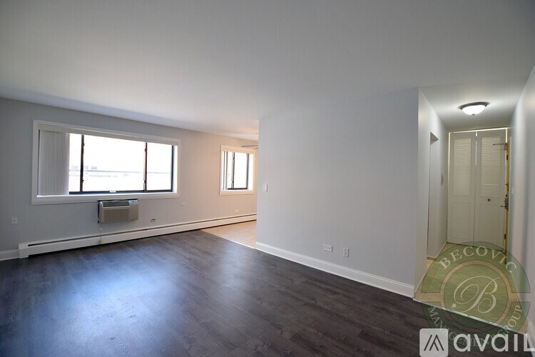 A large empty room with a window and a door.