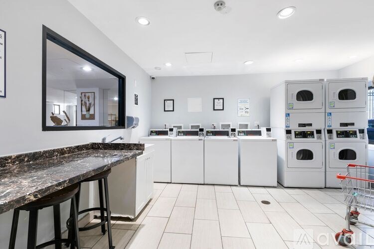 A clean, modern kitchen with white appliances and a marble countertop.