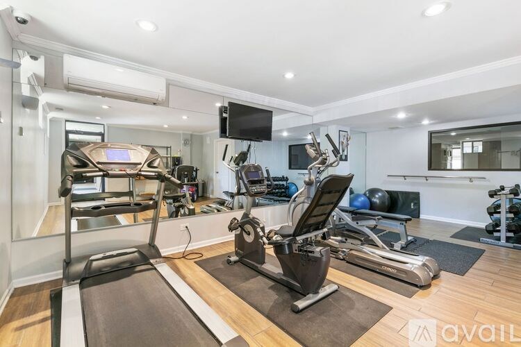 A well-equipped home gym with a treadmill, exercise bike, and other fitness equipment.