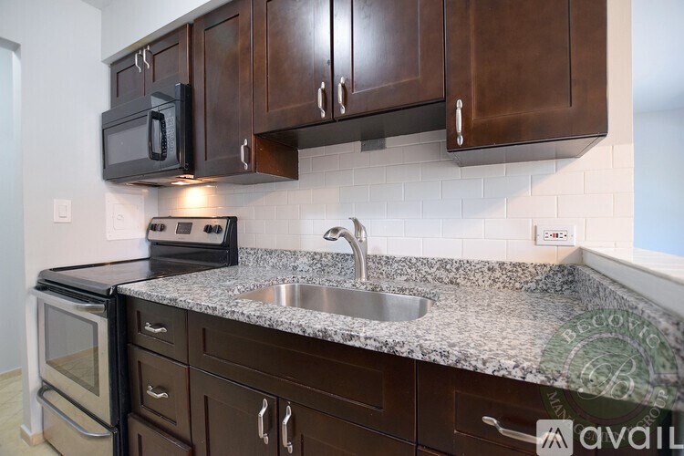 A kitchen with brown cabinets and a granite countertop.