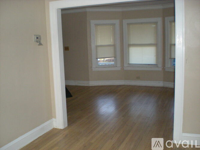 A room with wooden floors and two windows.