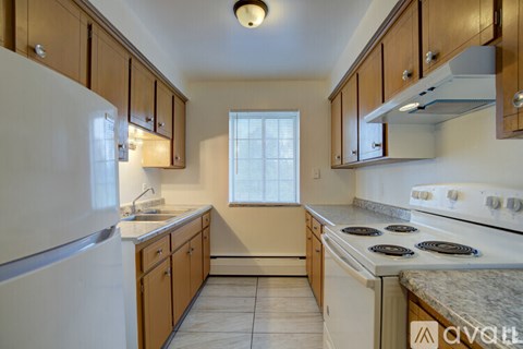 A kitchen with wooden cabinets and a white stove top oven.