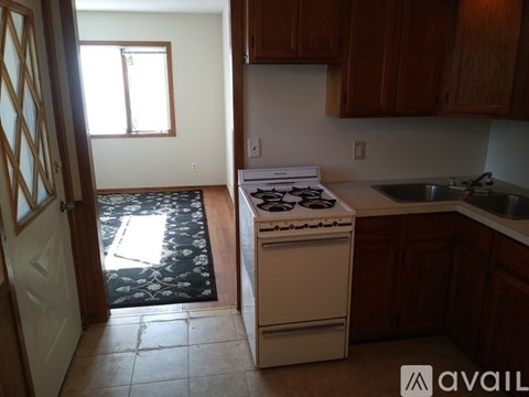 A kitchen with a white stove and wooden cabinets.