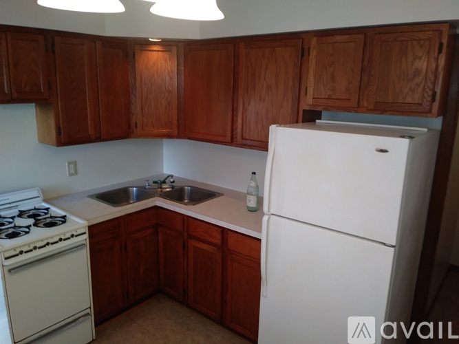 A kitchen with wooden cabinets and a white fridge.