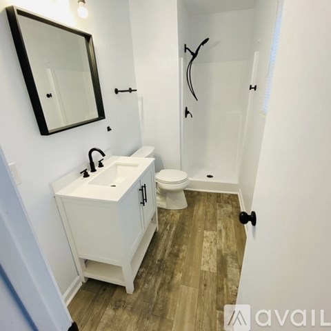 A bathroom with a toilet, sink, and mirror.