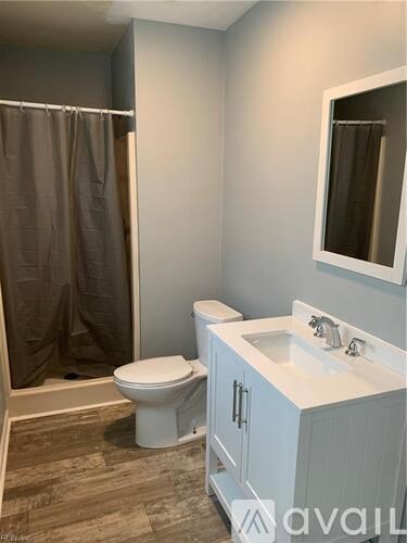 A room with a ceiling fan and wooden flooring.