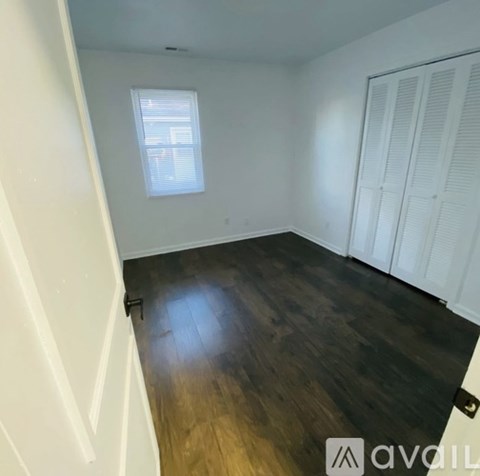 A room with wooden flooring and white walls.