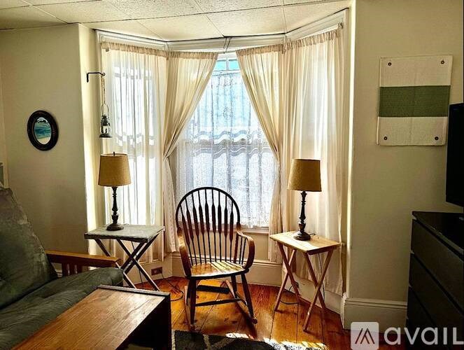 A living room with a chair, a couch, and two lamps.