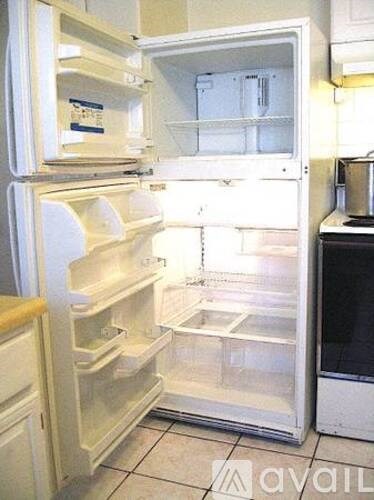 A white refrigerator with the door open and shelves visible.