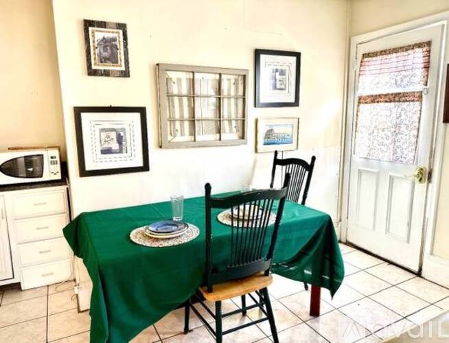 A dining room with a green tablecloth and a chair.