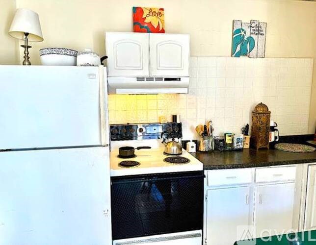 A kitchen with a white refrigerator and black oven.