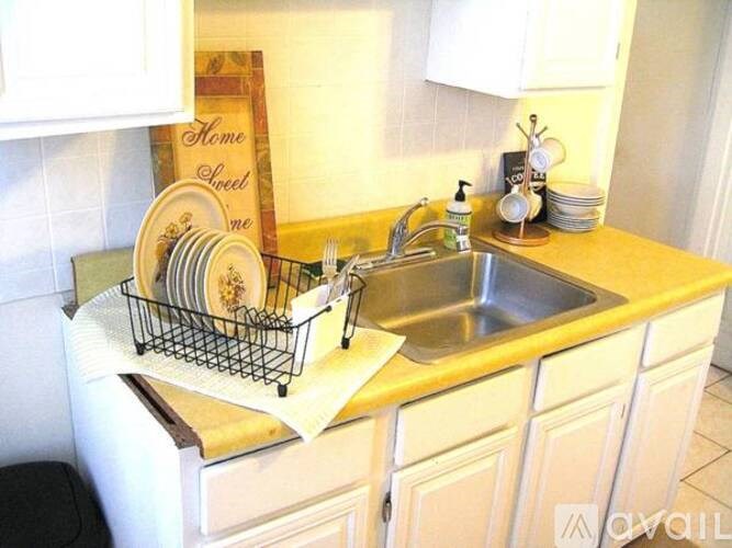 A kitchen with a sink and a sign that says Home Sweet Home.