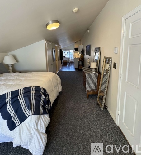 A bedroom with a bed and a dresser with a mirror.