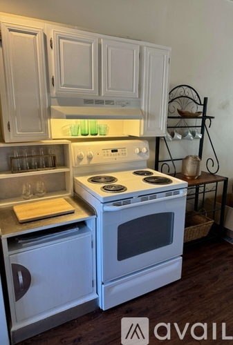 A white stove and oven in a kitchen with wooden floors.