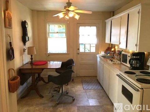A kitchen with a table and chairs in front of a window.