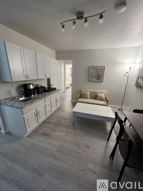 A kitchen with a marble countertop and a white sofa in the background.