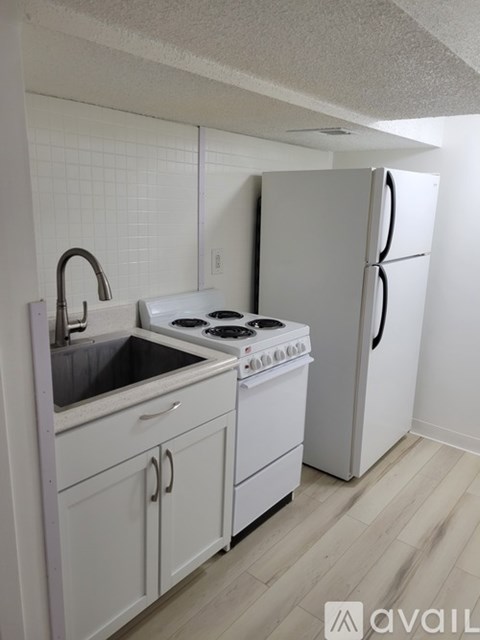A kitchen with white appliances and cabinets.
