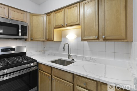 A kitchen with wooden cabinets and a black stove top oven.