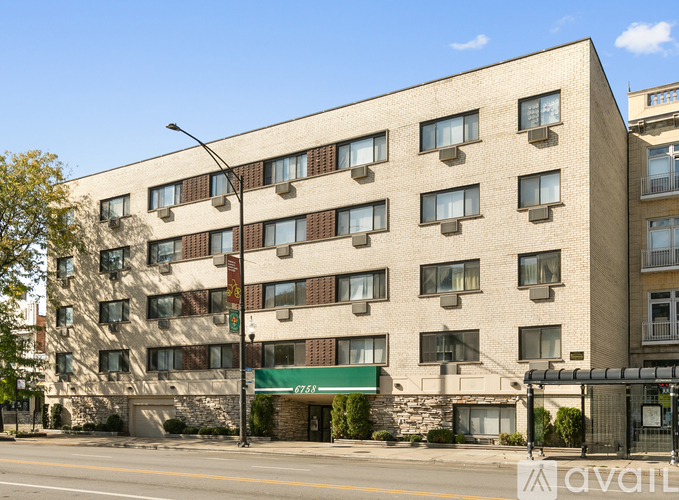A large beige building with a green awning on the front.