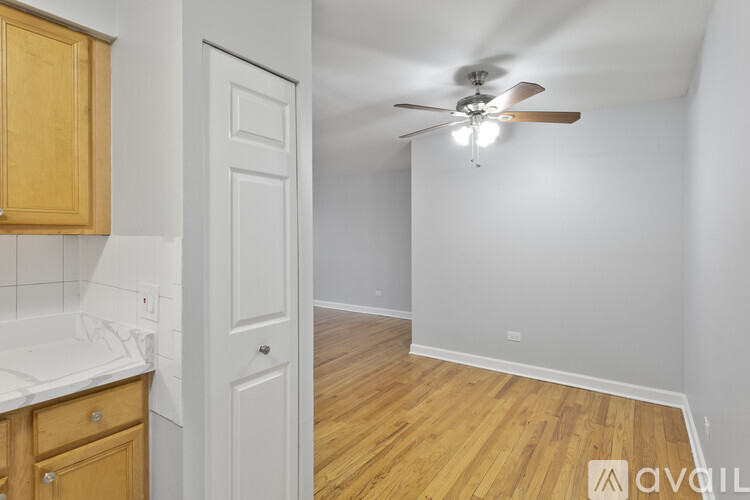 A room with a ceiling fan and wooden flooring.