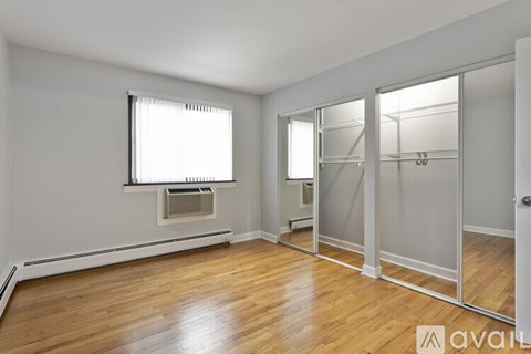 A room with wooden floors and a window with blinds.