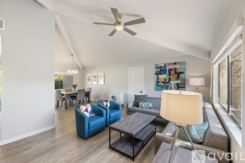 A living room with a blue couch and a wooden coffee table.