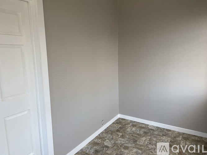 A room with a tiled floor and a white door.