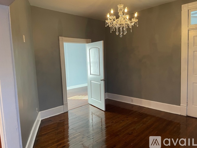 A room with a chandelier and a doorway leading to another room.