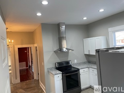 A kitchen with a black stove top oven and white cabinets.