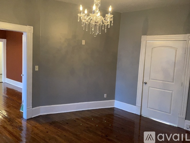 A room with a chandelier and a door.