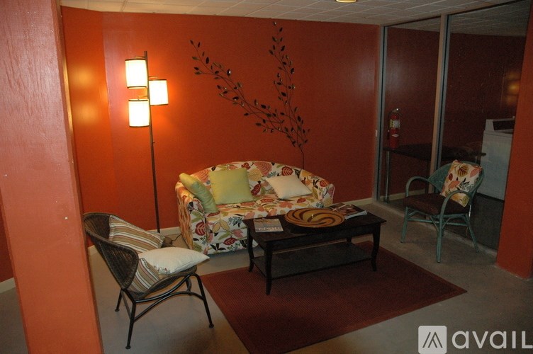 A living room with a sofa, chair, and lamp.