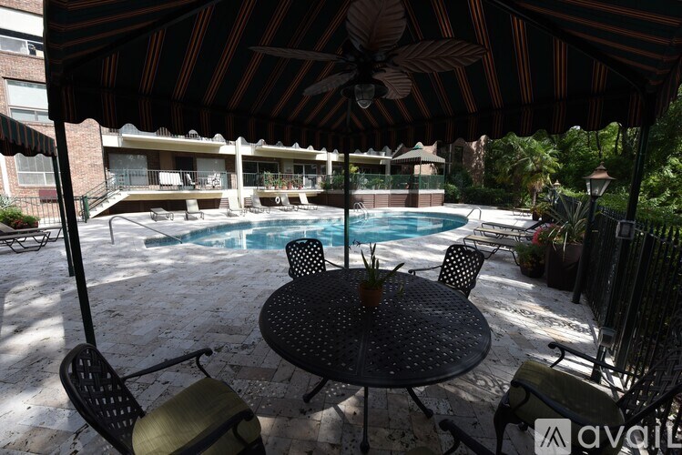 A patio with a table and chairs under an umbrella.